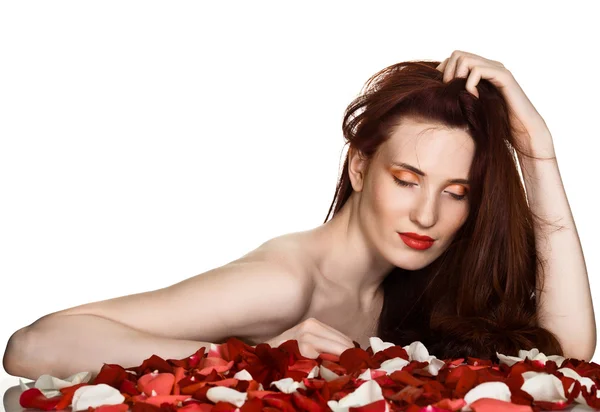 Красивая женщина и лепестки роз на белом фоне — стоковое фото