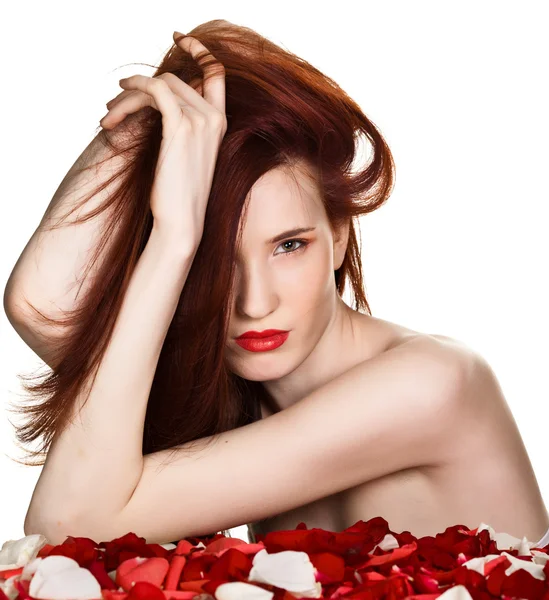 Piękna kobieta i płatki róż na białym tle — Zdjęcie stockowe
