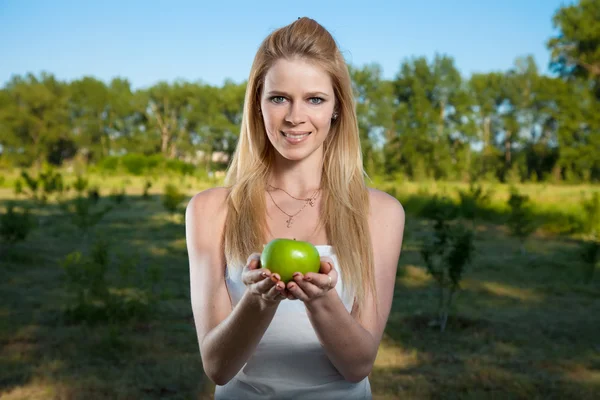 Retrato de uma jovem bonita com maçã verde ao ar livre — Fotografia de Stock