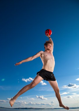 Male beach volleyball game player jump in blue sky clipart