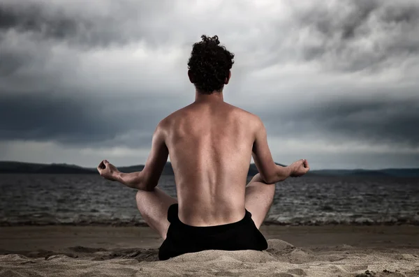 El hombre en la meditación en la orilla del mar — Foto de Stock