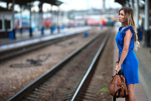 Привлекательная дама ждет поезд на платформе железнодорожного вокзала — стоковое фото