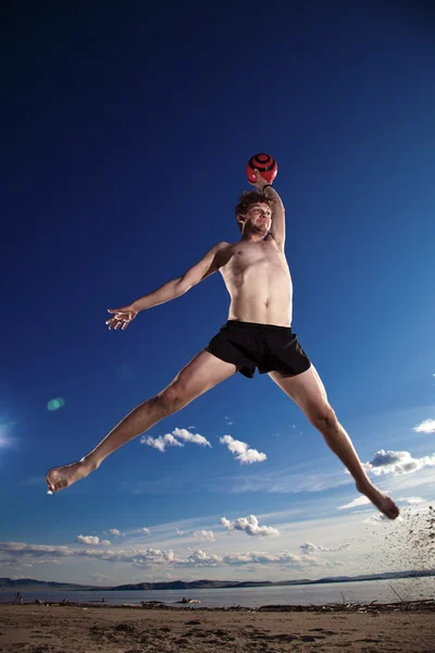 Mužské beach volejbal hry hráč skok v modré obloze — Stock fotografie