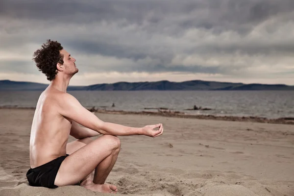 El hombre en la meditación en la orilla del mar — Foto de Stock