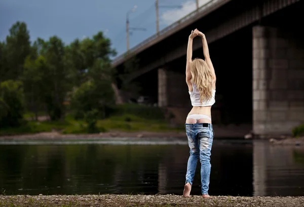 Молодая сексуальная женщина в джинсах на реке — стоковое фото