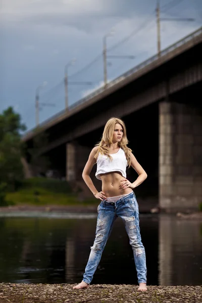 Ung sexig kvinna i jeans på floden — Stockfoto