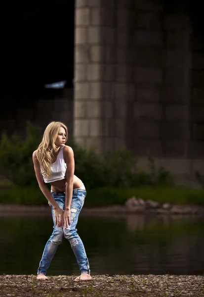 Ung sexig kvinna i jeans på floden — Stockfoto