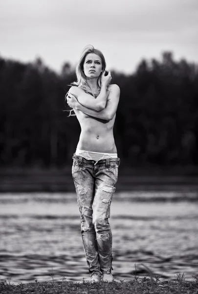 Junge sexy Frau in Jeans am Fluss. WB-Bild — Stockfoto