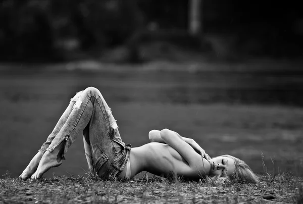 Молодая сексуальная женщина в джинсах на берегу реки. ВБ изображение — стоковое фото