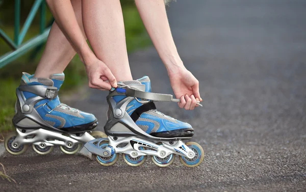 Jonge vrouw zetten rolschaatsen dicht omhoog — Stockfoto
