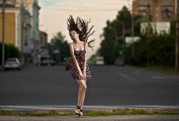 Osamělá žena městské na pozadí večerní město — Stock fotografie