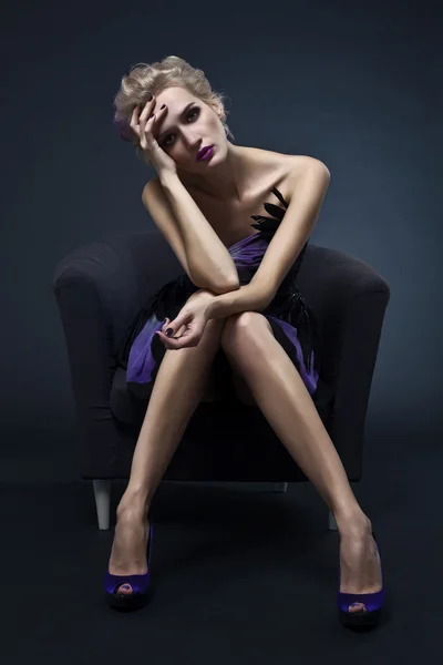 La imagen de una hermosa mujer de lujo sentada en la silla. Studi. — Foto de Stock