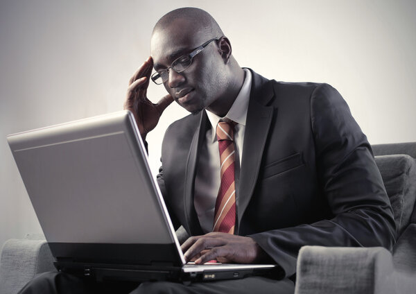 Concentrated african man using a laptop