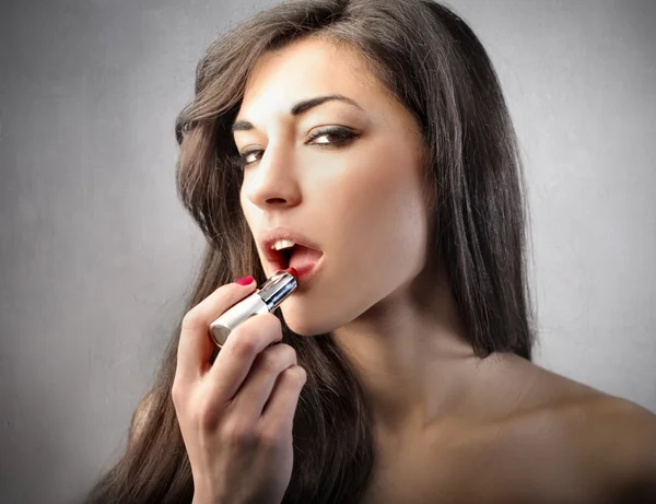 Schöne Frau zieht Lippenstift an — Stockfoto