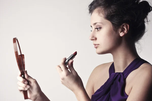 Beautiful woman putting on some makeup — Stock Photo, Image