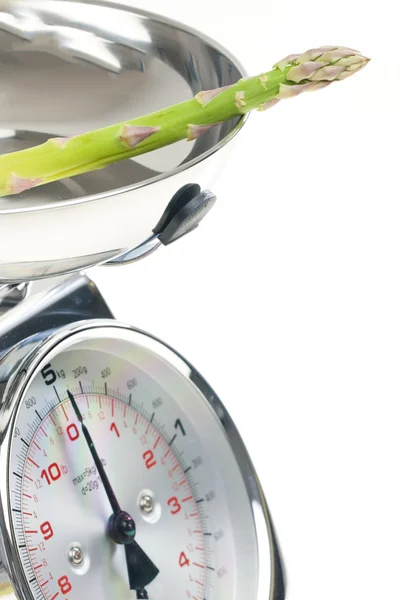Green asparagus on kitchen scales — Stock Photo, Image