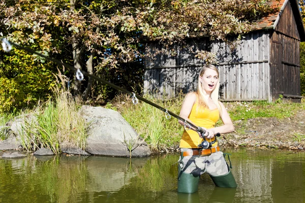 Женщина рыбачит в пруду — стоковое фото