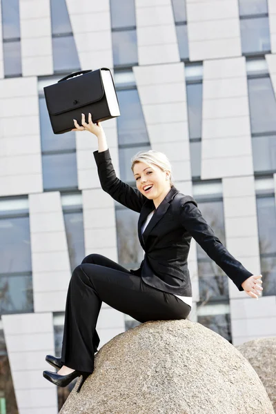 Sitzende junge Geschäftsfrau mit Aktentasche — Stockfoto
