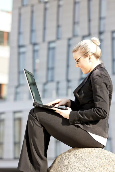 Сидя молодая деловая женщина с ноутбуком — стоковое фото