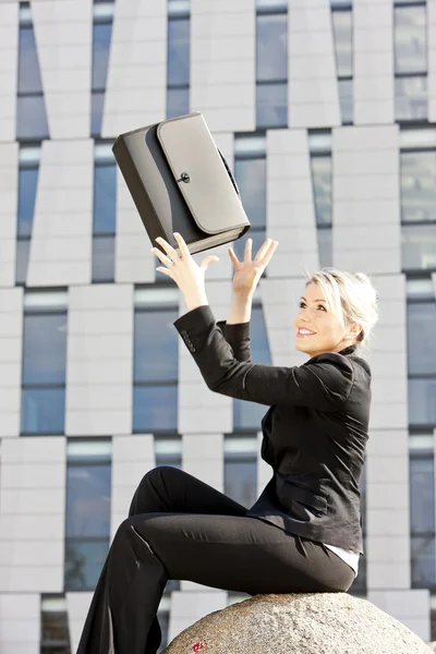Sitting young businesswoman with a briefcase — Stock Photo, Image