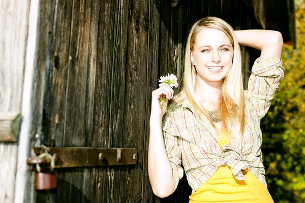 Portrét mladé ženy stojící s květinami — Stock fotografie