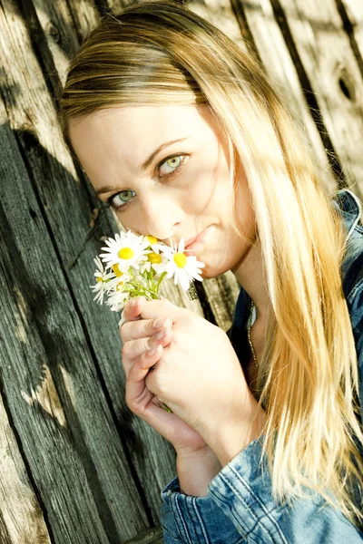 Retrato de mujer joven de pie con flores — Foto de Stock
