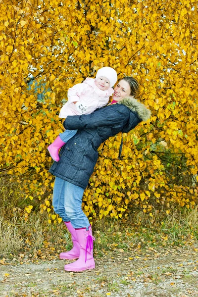 Mamma med sin dotter i höstliga naturen — Stockfoto