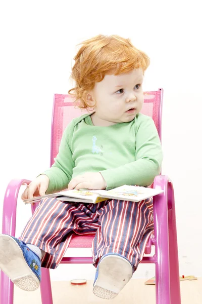 Μικρό αγόρι με ένα βιβλίο που κάθεται στην καρέκλα — Φωτογραφία Αρχείου