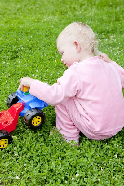 Liten flicka leker med lilla bil — Stockfoto