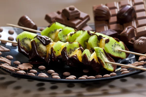 Fruitspiesjes en chocolade snoepjes — Stockfoto