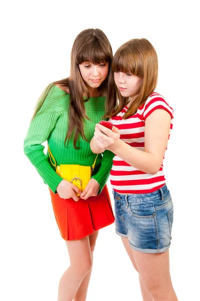 Twee schoolmeisjes kijken iets in de mobiele telefoon — Stockfoto