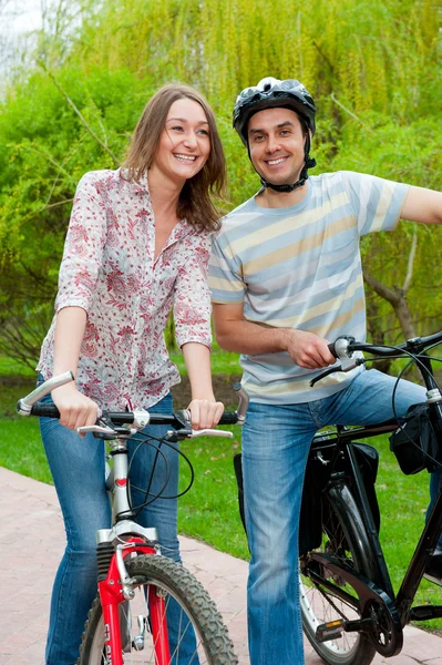 Feliz jovem casal equitação bicicletas — Fotografia de Stock