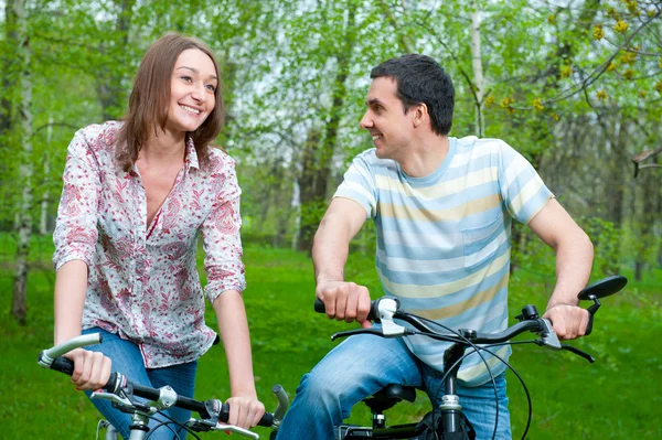Feliz jovem casal equitação bicicletas — Fotografia de Stock