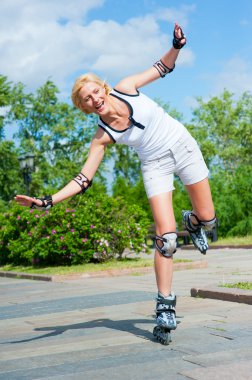 Girl roller-skating in the park clipart