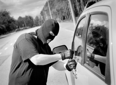 Thief breaks into a car door clipart