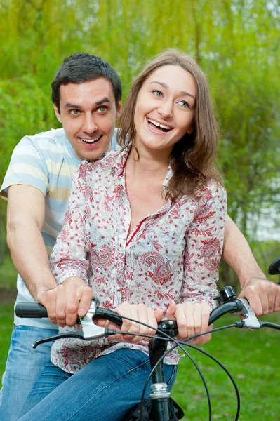 Feliz jovem casal andar de bicicleta — Fotografia de Stock
