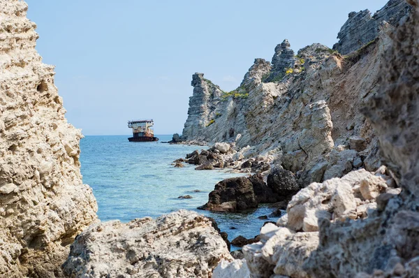 stock image Rusty sunken ship among the sea rocks