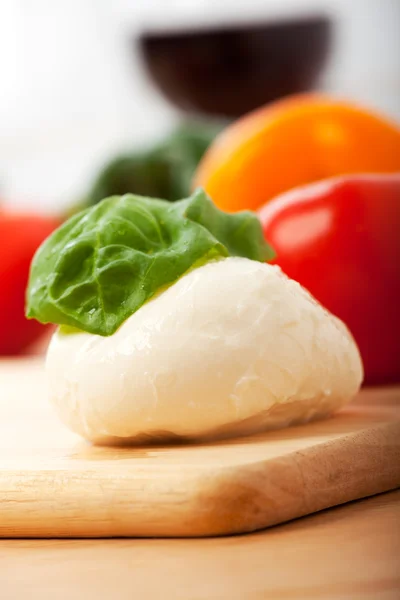 Mozzarella kaas en een blad van basilicum — Stockfoto