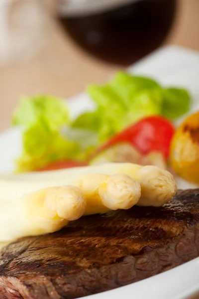 Witte asperges op een biefstuk — Stockfoto