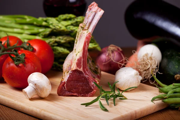 Carne de cordeiro em bruto e produtos hortícolas variados — Fotografia de Stock