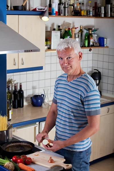 Bonito homem cozinhar macarrão na cozinha — Fotografia de Stock