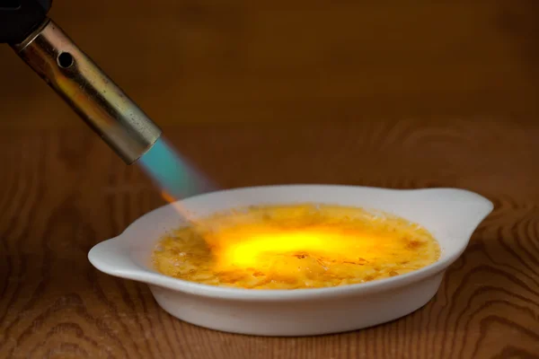 炎の caramelizing クリームのブリュレ — ストック写真