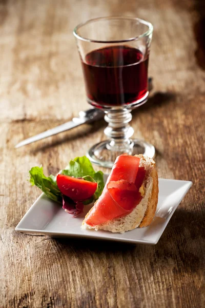 Close-up van een broodje ham en rode wijn — Stockfoto