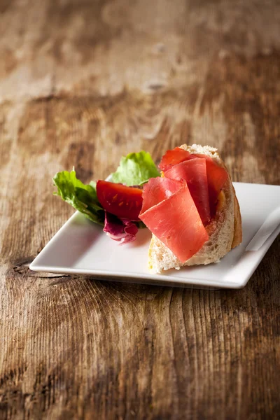 Крупный план бутерброда с ветчиной и красного вина — стоковое фото