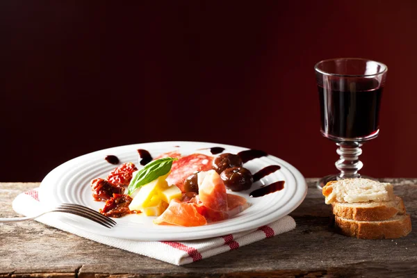 Gemengde Italiaanse antipasti op een bord met wijn — Stockfoto