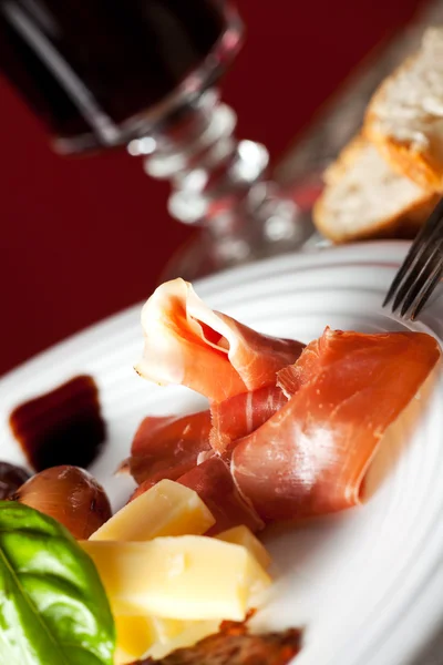 Mixed italian antipasti on a plate with wine — Stock Photo, Image