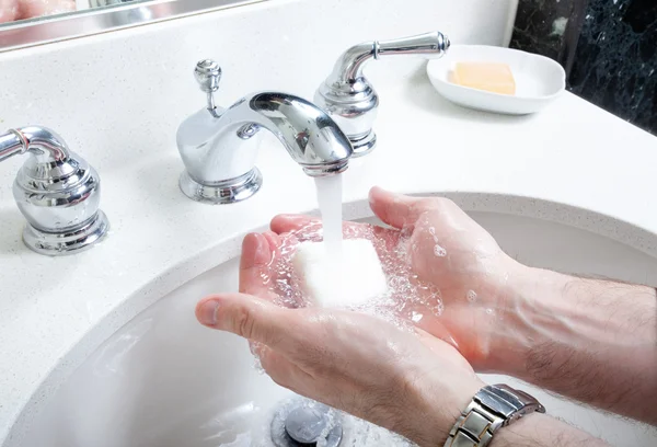 Washing hands with soap in washroom sink — Stock Photo, Image