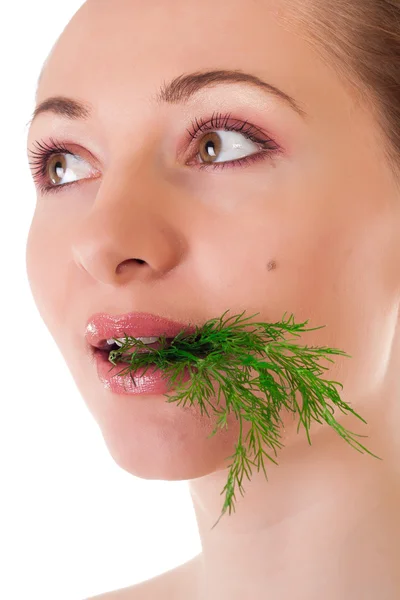 stock image Young female model holding a batch of fresh green dill in her teeth