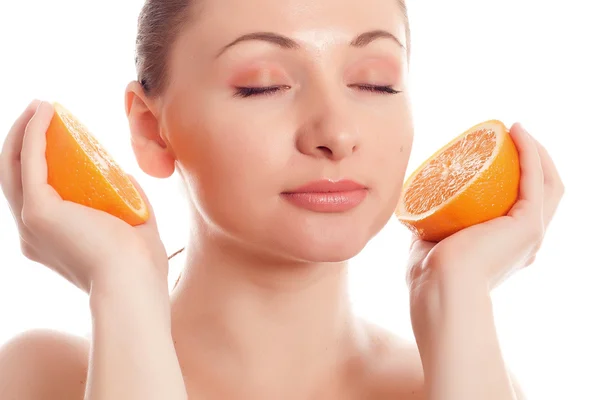 Mujer sosteniendo mitades de naranjas como auriculares — Foto de Stock