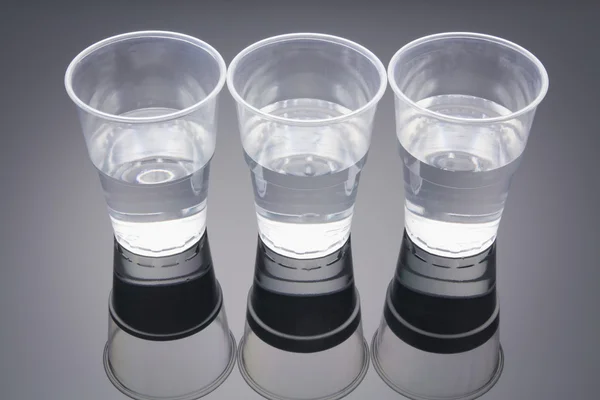 Água em copos de plástico — Fotografia de Stock